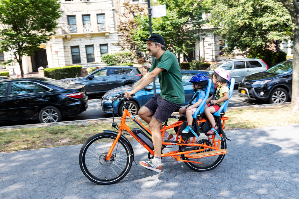 RadWagon electric cargo bike with adult rider and 2 child passengers